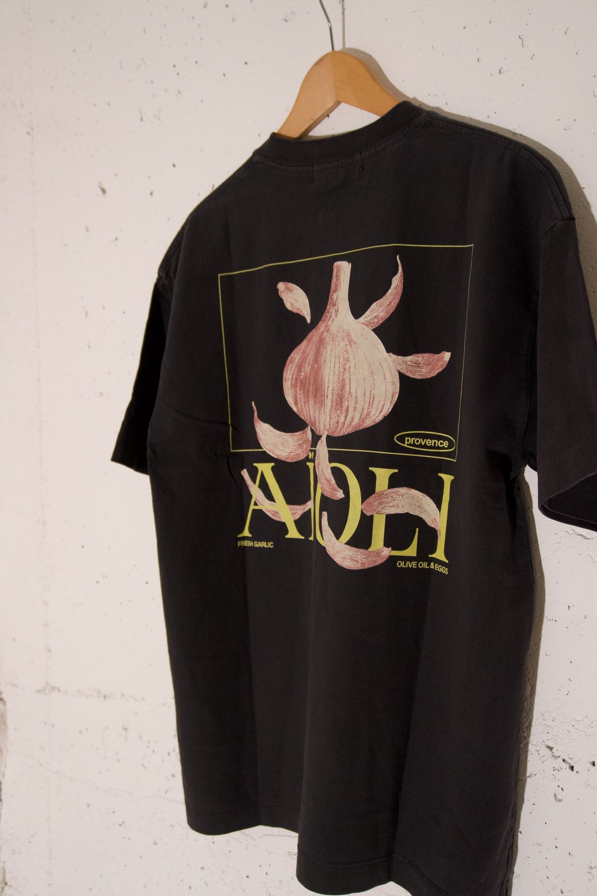 T-shirt Aïoli Noir minéral photographié de dos sur cintre